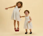 Children jumping wearing Ten Little Velvet Ballet Flats - Burgundy Red and Classic Black. Available from www.tenlittle.com