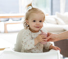 Baby Holding Ezpz Mini Cup & Straw in Blush - Available at www.tenlittle.com