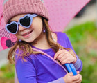 Girl holding umbrella wearing Ten Little Roshambo Heart Sunglasses - Lilac. Available at www.tenlittle.com