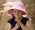 Girl wearing Jan & Jul AquaDry Bucket Hat - Pink. Available at www.tenlittle.com