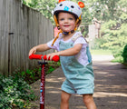 Child riding scooter wearing Micro Kickboard Micro Helmet - Monster. Available at www.tenlittle.com