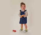 Girl holding toy wearing Ten Little First Walkers - Sage Green. Available at www.tenlittle.com