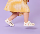 Side view of girl wearing Ten Little Splash Sandals 2 - Soft White. Available at www.tenlittle.com